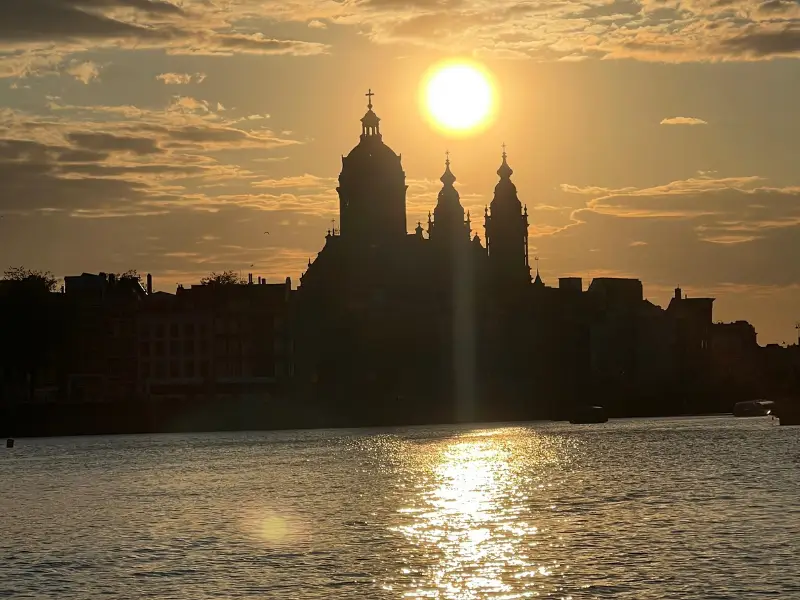 Sunset over Amsterdam. The ideal moment to enjoy a golden-hour canal cruise through the city-centre of Amsterdam.