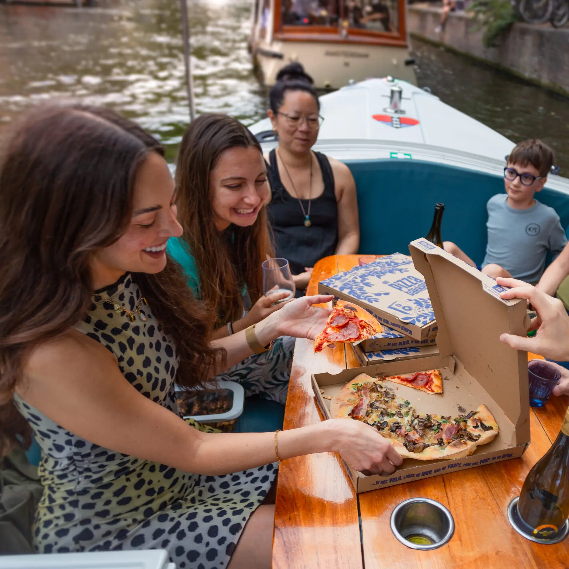 Enjoying delicious pizza on board our cozy canal cruise in Amsterdam.